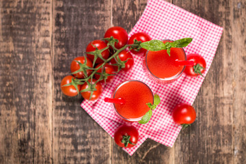 Fototapeta na wymiar Tomato Juice and Fresh Tomatoes on a Wooden Background
