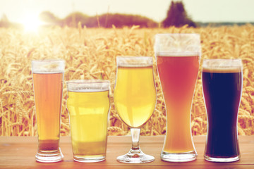 close up of different beers in glasses on table