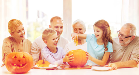 happy family sitting with pumpkins at home