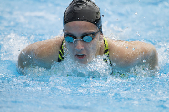 Nadadora profesional entrenando en piscina al aire libre estilo mariposa