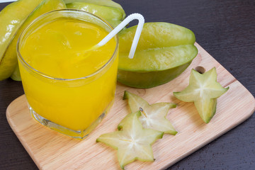 Star apple juice or averrhoa carambola squash on wooden block. Fresh star apple juice on wood table.