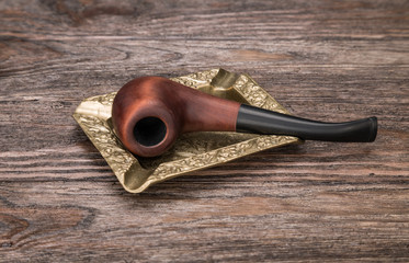 Smoking pipe in an ashtray