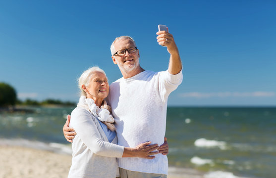 happy senior couple hugging on summer beach