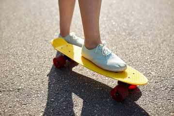 close up of female feet riding short skateboard