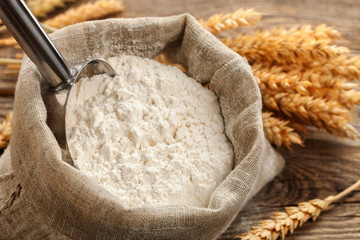 Wheat flour in a bag with wheat spikelets . - 120005524