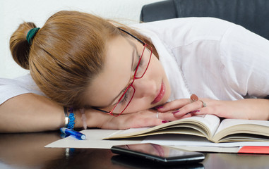 College student fallen asleep on book during studying