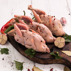 Fresh organic quails on vintage wooden table, healthy food
