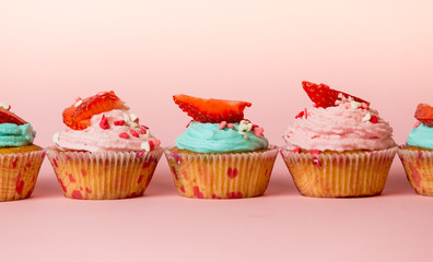 Closeup of colorful cupcakes with sprinkles and berries on top