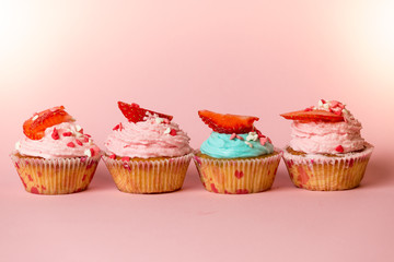 Closeup of colorful cupcakes with sprinkles and fresh strawberry