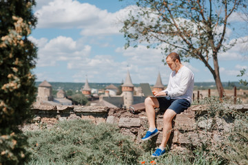 Attractive man working with laptop in the park.
