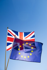 European Union and British Union Jack flag flying backlit in front of bright blue sky in the wake of the Brexit EU referendum