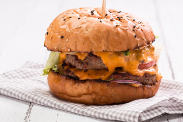 Tasty grilled burger with lettuce and mayonnaise ,on a rustic wooden table