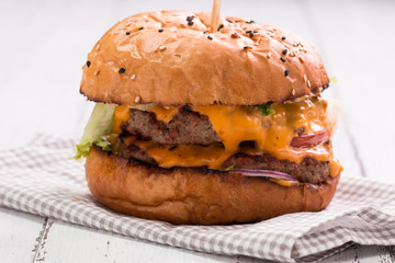 Tasty grilled burger with lettuce and mayonnaise ,on a rustic wooden table