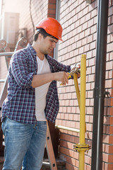 Young plumber in hardhat repairing pipes