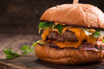 Tasty grilled burger with lettuce and mayonnaise ,on a rustic wooden table
