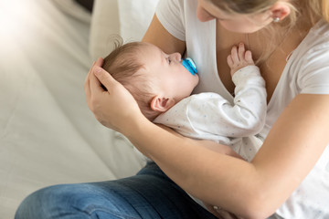 Toned image of baby boy sleeping on mothers hands