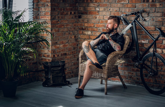 The Bearded Hipster Male Relaxing In A Chair.