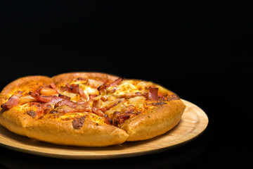 Hawaiian pizza on a wooden tray.