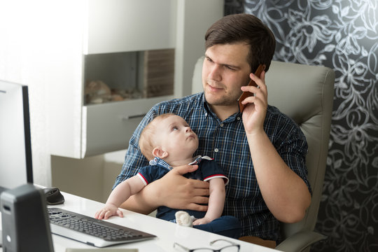 Father talking by phone and taking care of his baby