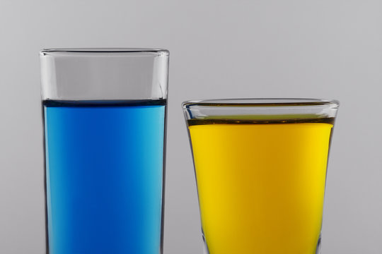 blue and yellow cocktails in clean shot glasses