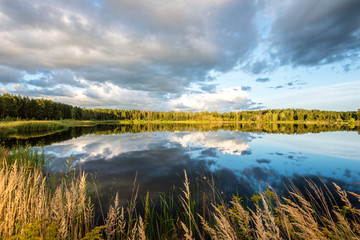 Obraz premium Beautiful summer sunset at the lake with blue sky, red and orang