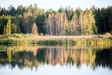 Beautiful autumn sunset at the lake with blue sky, red and orang