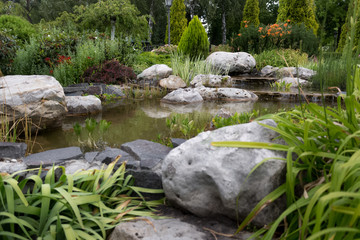 Naklejka na ściany i meble Closeup of beautiful fast stream in formal garden. Landscape des