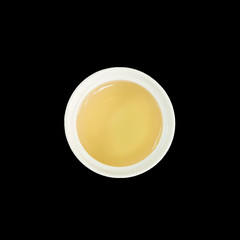 Closeup brown tea in white ceramic cup isolated on black background in top view with clipping path