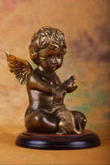 angel boy with a dog from a bronze on the  yellow background