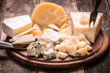 Composition of cheese, berries, bottles and glasses of wine on a wooden table