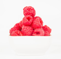 Raspberries: a bowl of fruit on white background