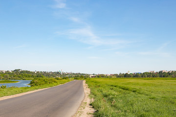 Fototapeta premium Asphalt road in green summer field