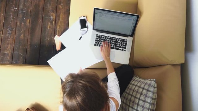 Woman works with laptop and documents