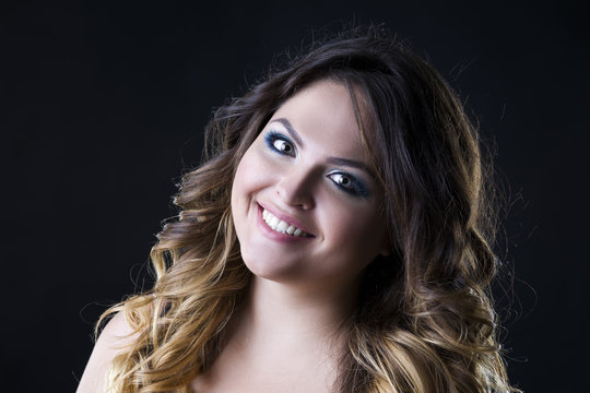 Young beautiful caucasian woman with professional makeup and hairstyle on black background