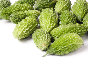 heap of bitter melon or momordica with leaves isolated on white background