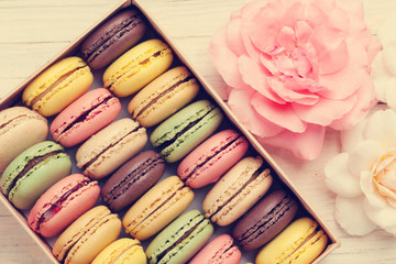 Colorful macaroons in a gift box and roses