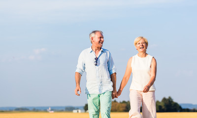 Senior woman and man holding hands having walk