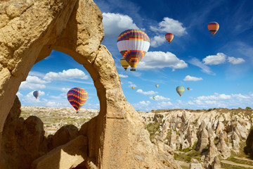 Hot air balloons flies in blue sky in Kapadokya, Turkey