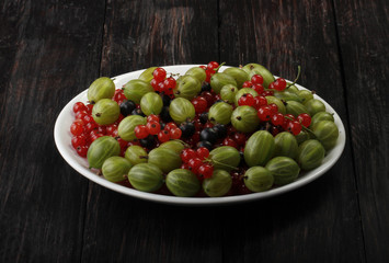 berries in plate on wooden background