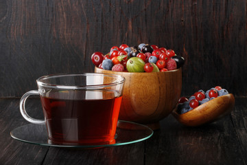 tea and berries on wooden background