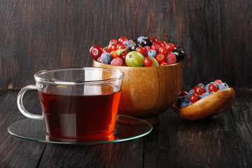 tea and berries on wooden background