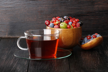 tea and berries on wooden background