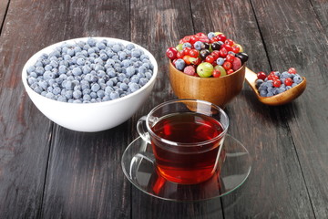 tea and berries on wooden background