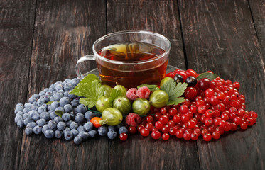 tea with berries on wooden background