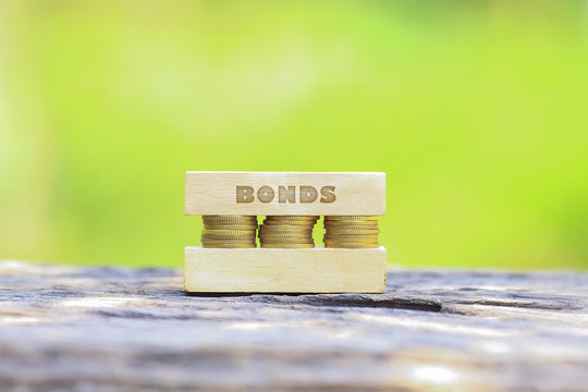 Business Concept -BONDS WORD, Golden coin stacked with wooden ba