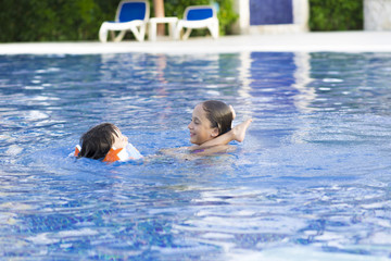 Happy Girl and Boy Enjoying in Swimming Pool