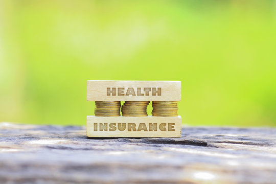 Business Concept - HEALTH INSURANCE WORD, Golden coin stacked