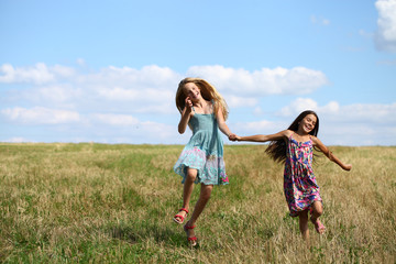 Fototapeta premium Two little girls running in summer field