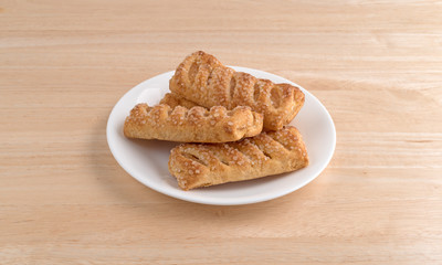 Apple fruit tarts on a plate atop a wood table.