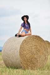 Naklejka na ściany i meble Young american cowgirl woman portrait outdoors. 